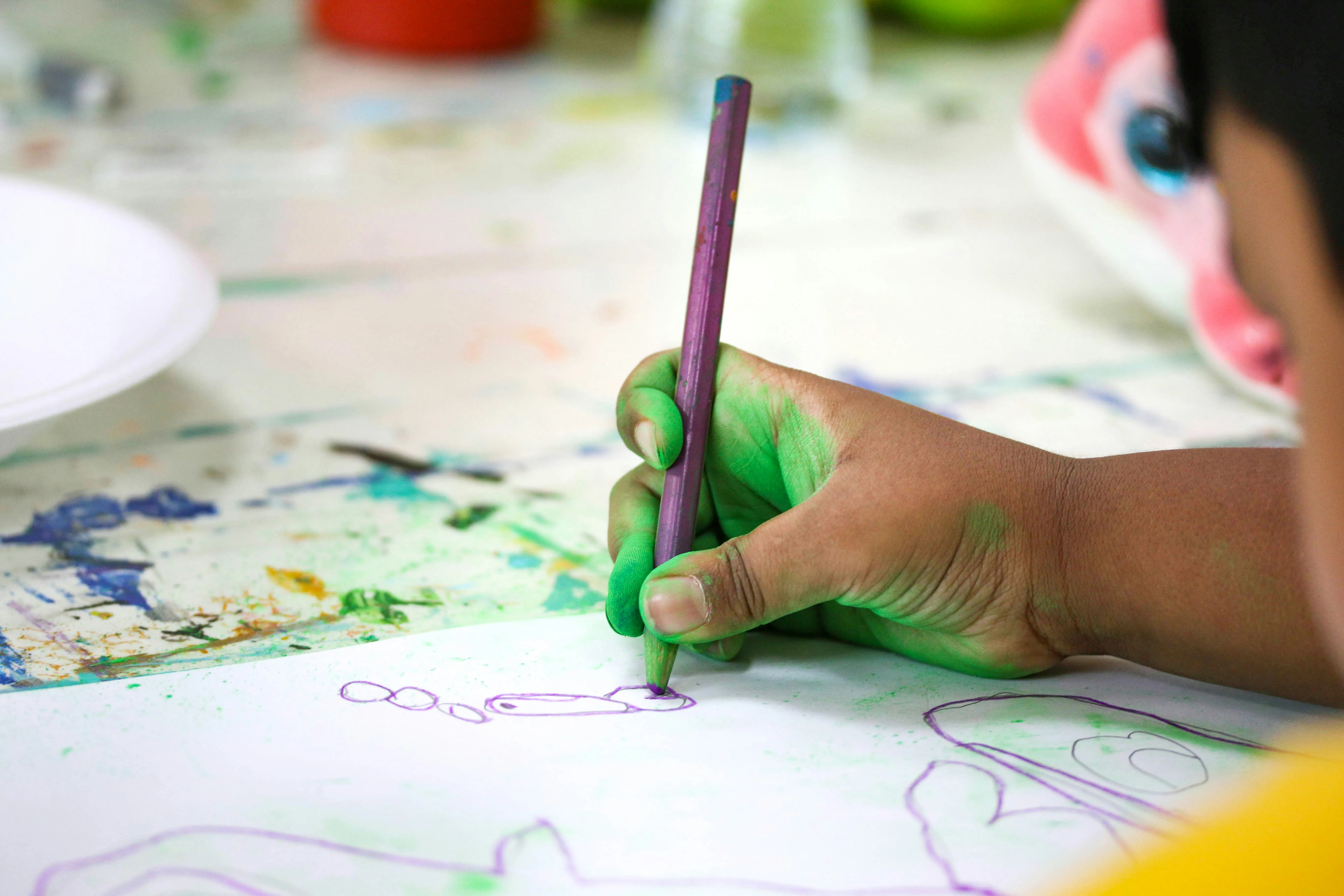 child drawing with paint on hand